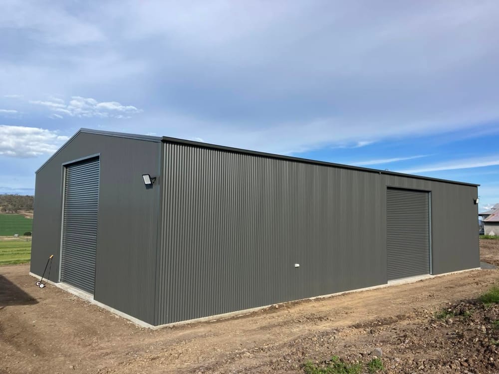 Grey Colorbond garage and workshop shed with roller doors, built by Mark Collins Builder